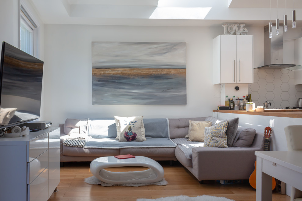 Immagine di un piccolo soggiorno minimal chiuso con pareti bianche, pavimento in legno massello medio, TV autoportante e pavimento marrone