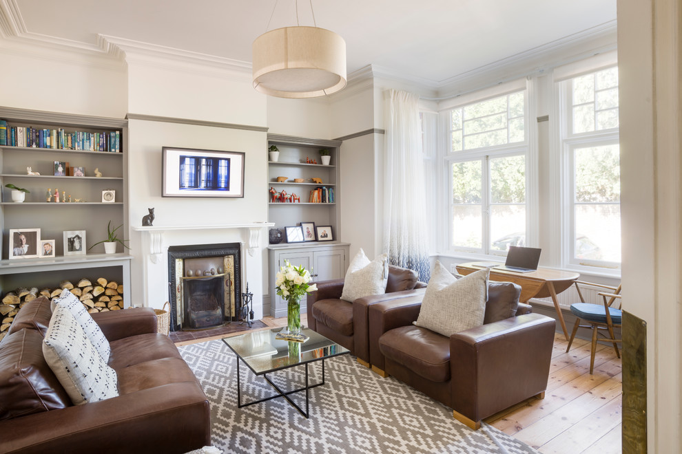 Inspiration for a mid-sized victorian enclosed light wood floor and brown floor living room remodel in London with gray walls, a wood stove, a tile fireplace and a wall-mounted tv