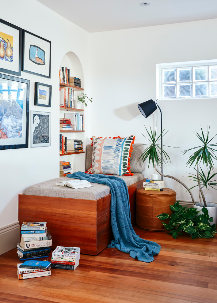 Photo of a bohemian living room in Melbourne with medium hardwood flooring, brown floors and white walls.