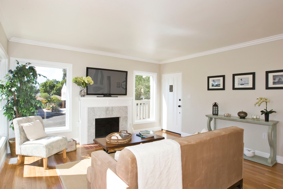 На фото: гостиная комната в классическом стиле с бежевыми стенами, стандартным камином и отдельно стоящим телевизором