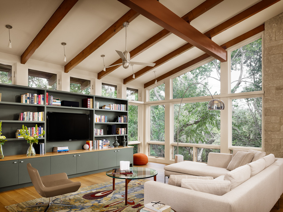 Modernes Wohnzimmer mit TV-Wand und Steinwänden in Austin