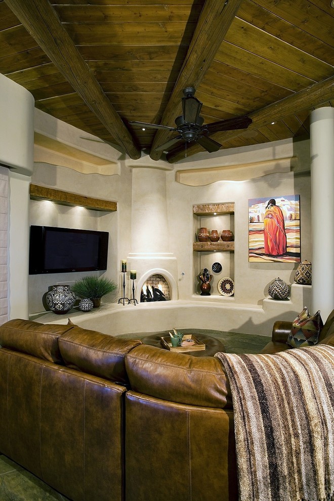 Mittelgroßes, Offenes Mediterranes Wohnzimmer mit beiger Wandfarbe, Schieferboden, Eckkamin, verputzter Kaminumrandung, TV-Wand und grauem Boden in Phoenix