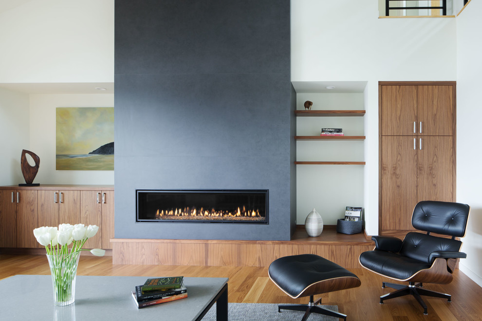 シアトルにあるコンテンポラリースタイルのおしゃれなLDK (白い壁、無垢フローリング、標準型暖炉、タイルの暖炉まわり) の写真