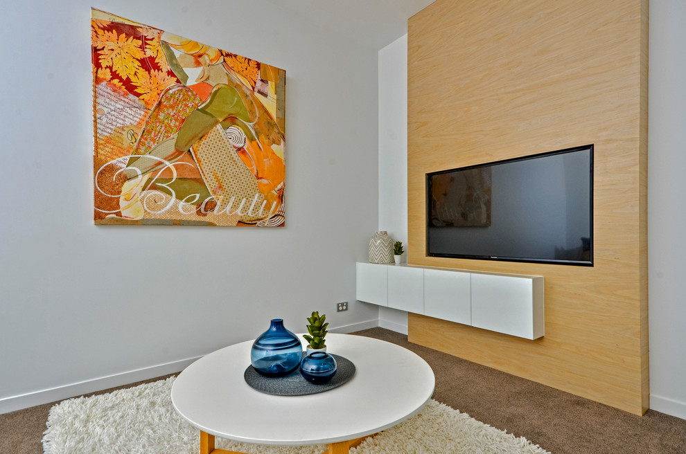 Immagine di un grande soggiorno minimalista aperto con sala formale, pareti bianche, moquette, TV a parete e pavimento beige