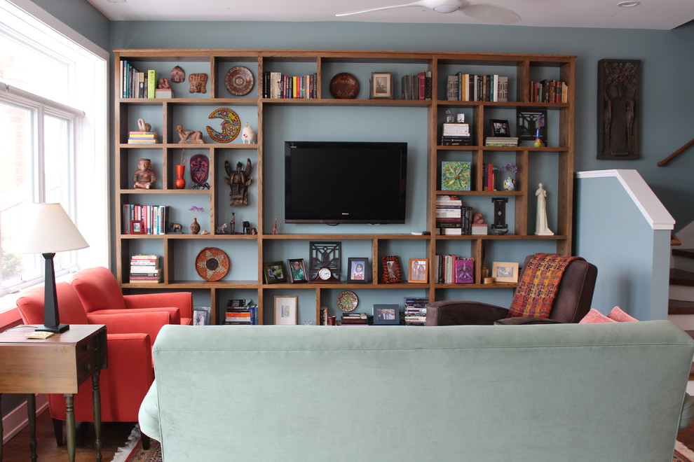 Idee per un soggiorno classico di medie dimensioni e aperto con pareti blu, pavimento in legno massello medio, TV a parete, libreria e nessun camino