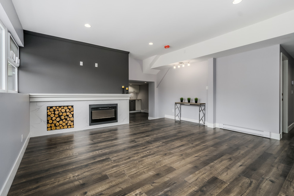 Großes, Abgetrenntes Modernes Wohnzimmer mit grauer Wandfarbe, dunklem Holzboden, TV-Wand und Gaskamin in Vancouver