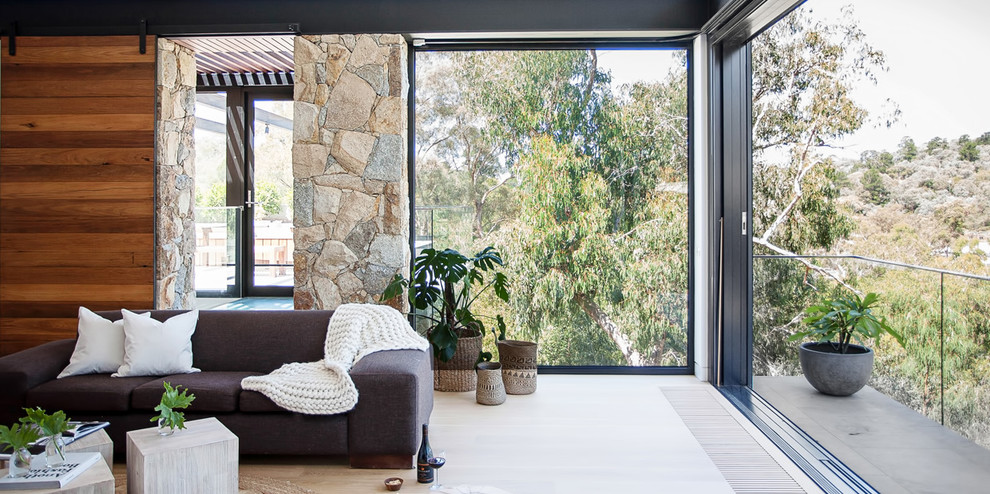 Inspiration for a mid-sized contemporary open concept medium tone wood floor living room remodel in Melbourne with white walls and a wall-mounted tv