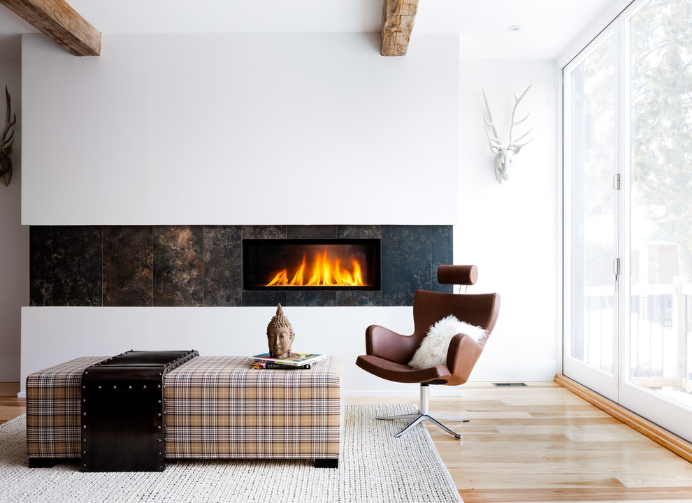 Fernseherloses Modernes Wohnzimmer mit weißer Wandfarbe, braunem Holzboden, Gaskamin und gefliester Kaminumrandung in Toronto