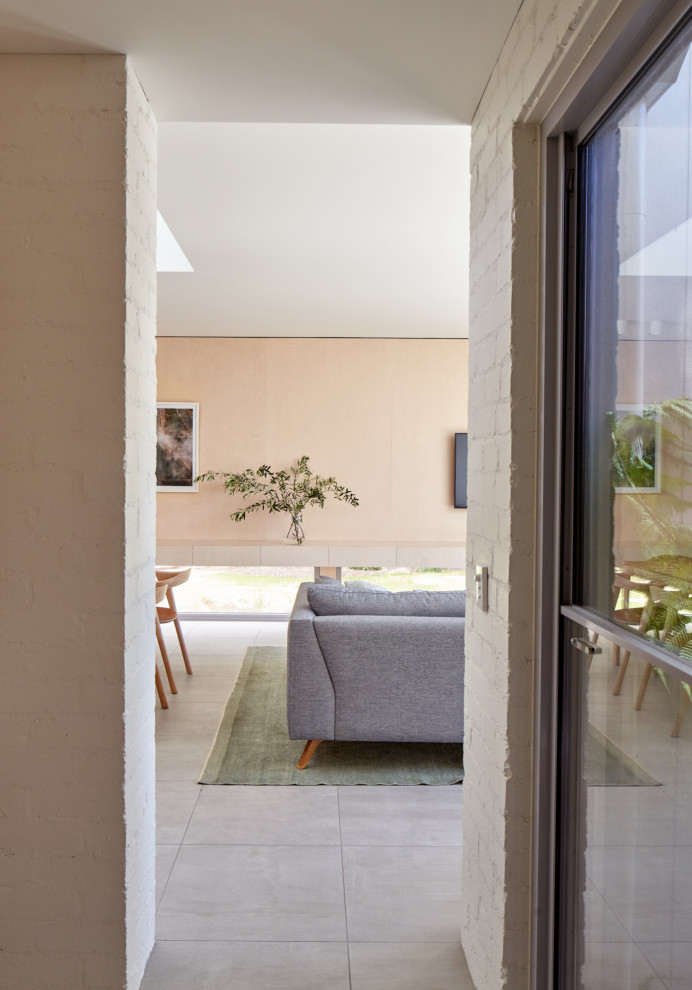 Foto di un soggiorno minimal di medie dimensioni e aperto con pavimento con piastrelle in ceramica e pavimento grigio