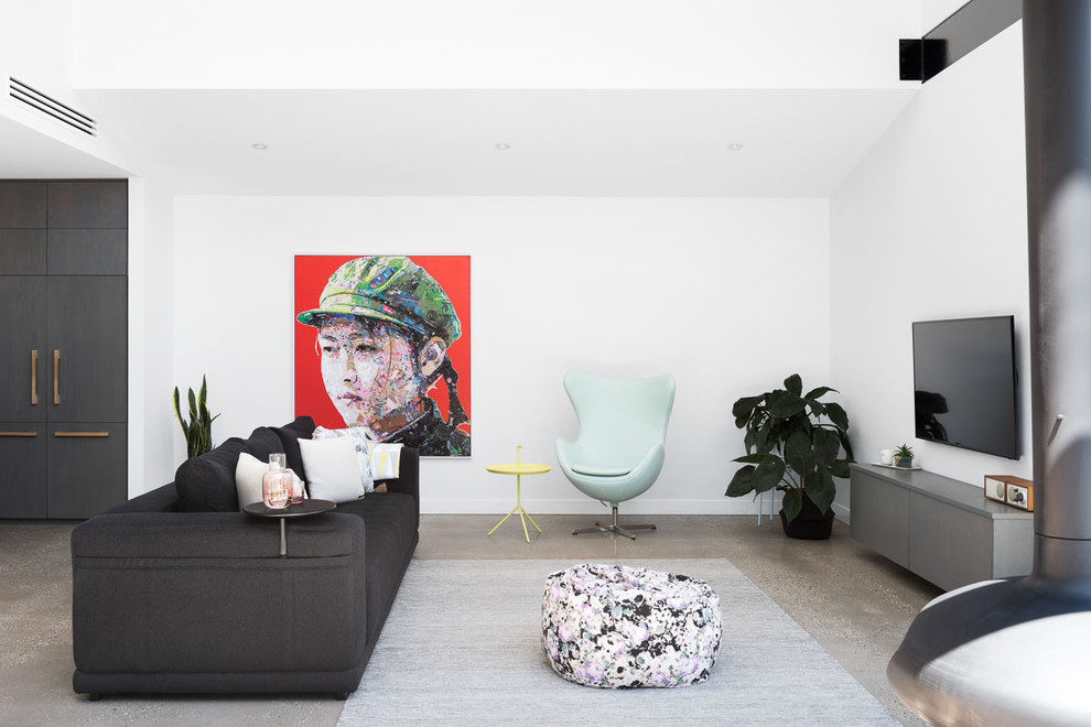 Mittelgroßes, Offenes Modernes Wohnzimmer mit weißer Wandfarbe, Betonboden, Hängekamin, TV-Wand und grauem Boden in Melbourne