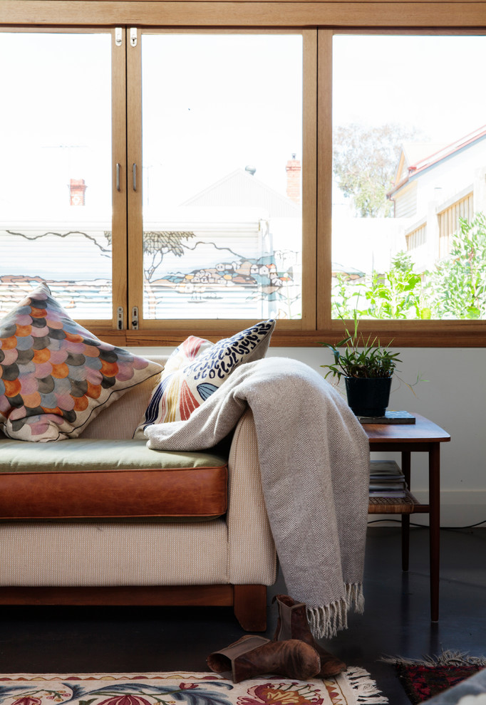 На фото: маленькая открытая гостиная комната в современном стиле с белыми стенами, бетонным полом, печью-буржуйкой, фасадом камина из кирпича и скрытым телевизором для на участке и в саду