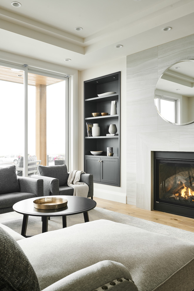 This is an example of a medium sized contemporary formal open plan living room in Vancouver with a standard fireplace, brown floors, white walls, light hardwood flooring, a metal fireplace surround and no tv.