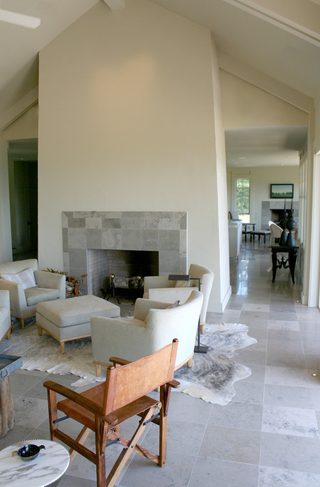 Idee per un soggiorno classico con pareti bianche, pavimento in gres porcellanato, camino classico e cornice del camino in pietra