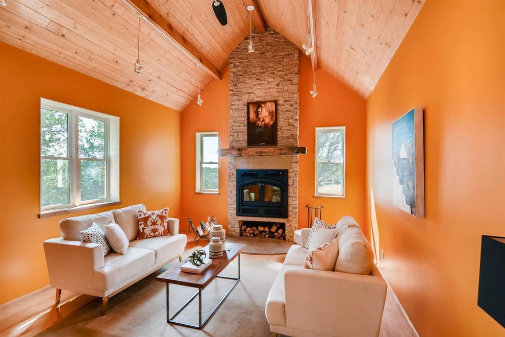 Inspiration för ett mellanstort amerikanskt separat vardagsrum, med orange väggar, mellanmörkt trägolv, en standard öppen spis, en spiselkrans i sten och beiget golv