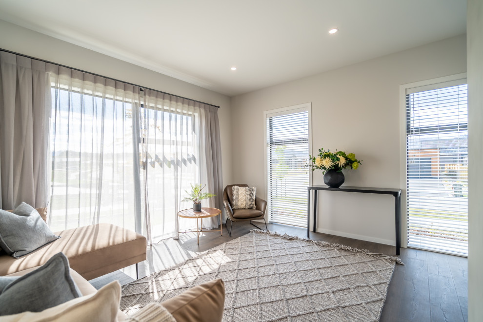 Immagine di un piccolo soggiorno minimalista aperto con pareti bianche, pavimento in laminato e pavimento marrone