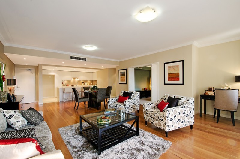 Immagine di un soggiorno minimal con pareti beige e pavimento in legno massello medio