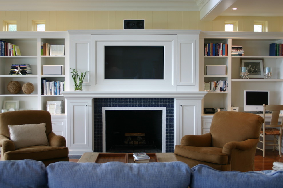Пример оригинального дизайна: гостиная комната в классическом стиле с фасадом камина из плитки, желтыми стенами и синим диваном