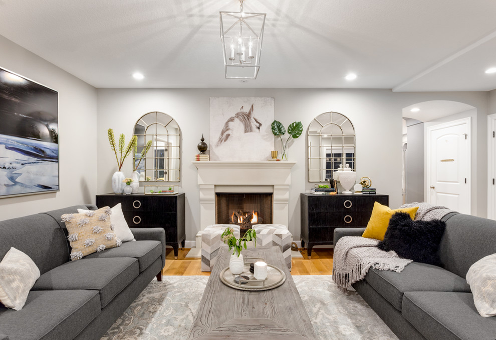 Источник вдохновения для домашнего уюта: гостиная комната в стиле неоклассика (современная классика) с серыми стенами, паркетным полом среднего тона, стандартным камином и коричневым полом