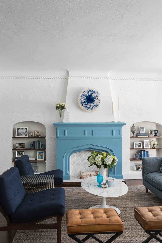 Aménagement d'un salon classique avec un mur blanc, parquet foncé, une cheminée standard et un manteau de cheminée en plâtre.