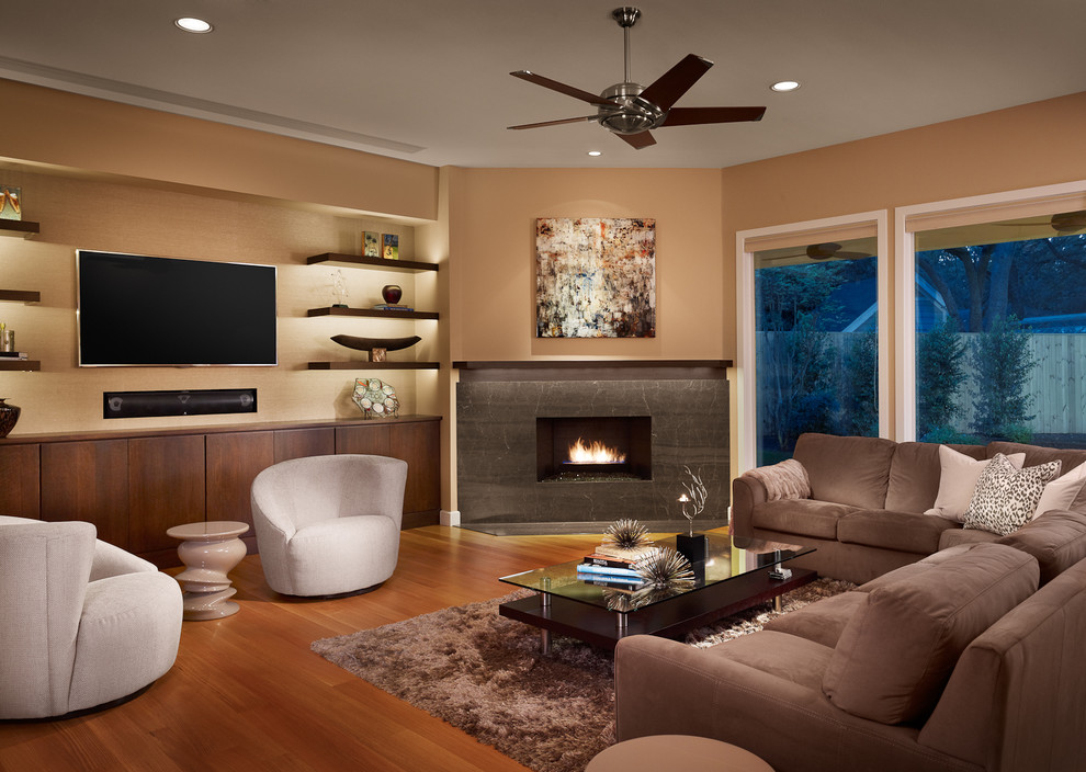 Inspiration for a large contemporary open concept medium tone wood floor living room remodel in Austin with a corner fireplace, beige walls, a stone fireplace and a wall-mounted tv