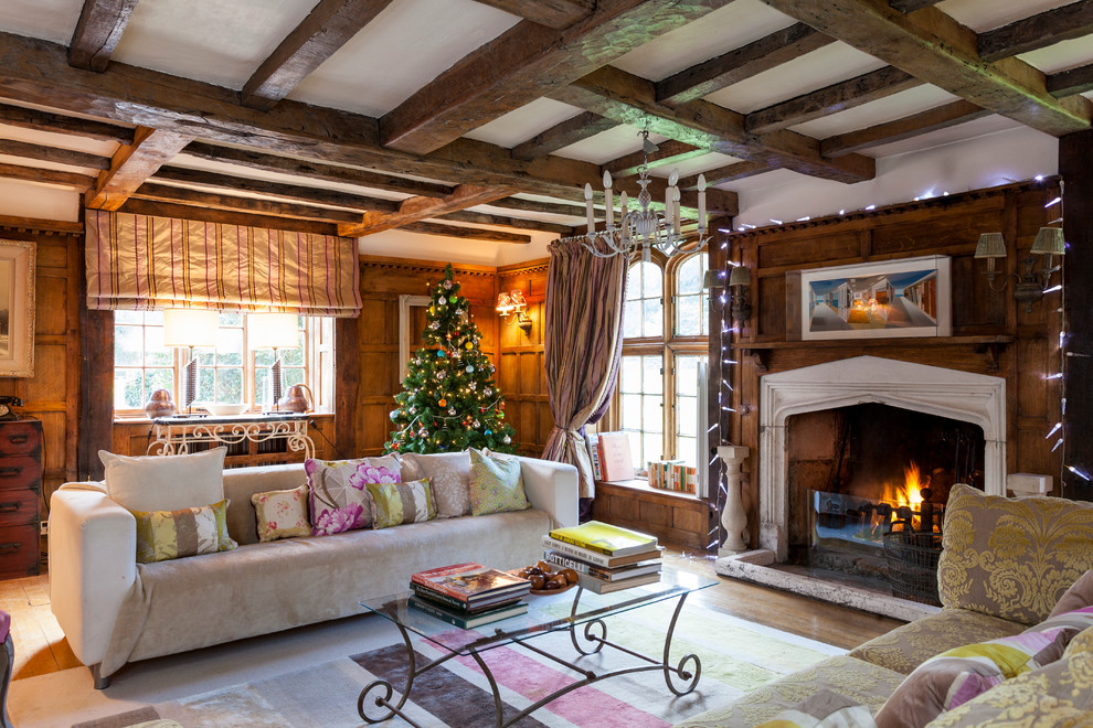Cette image montre un salon traditionnel avec un mur blanc, un sol en bois brun et une cheminée standard.