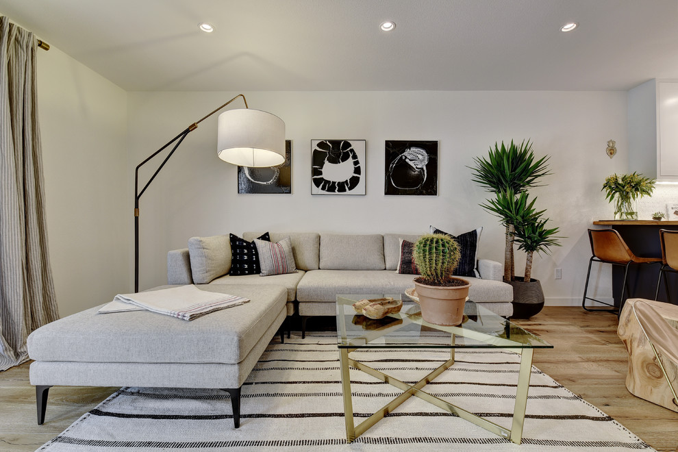 Ispirazione per un soggiorno design aperto con pareti bianche e parquet chiaro