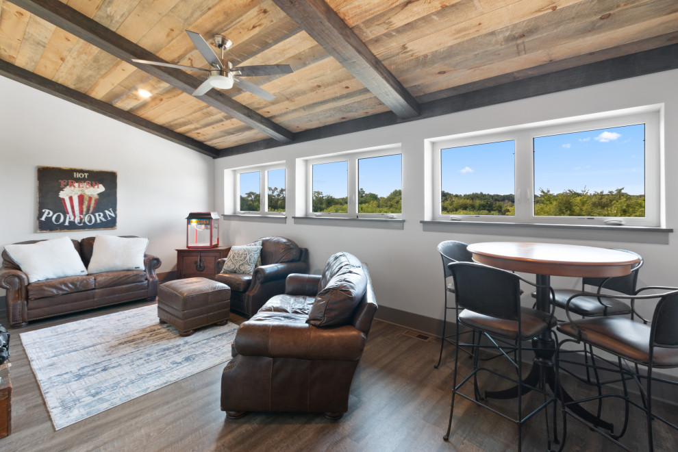 На фото: большая открытая гостиная комната в стиле лофт с белыми стенами, бетонным полом, телевизором на стене, коричневым полом и деревянным потолком