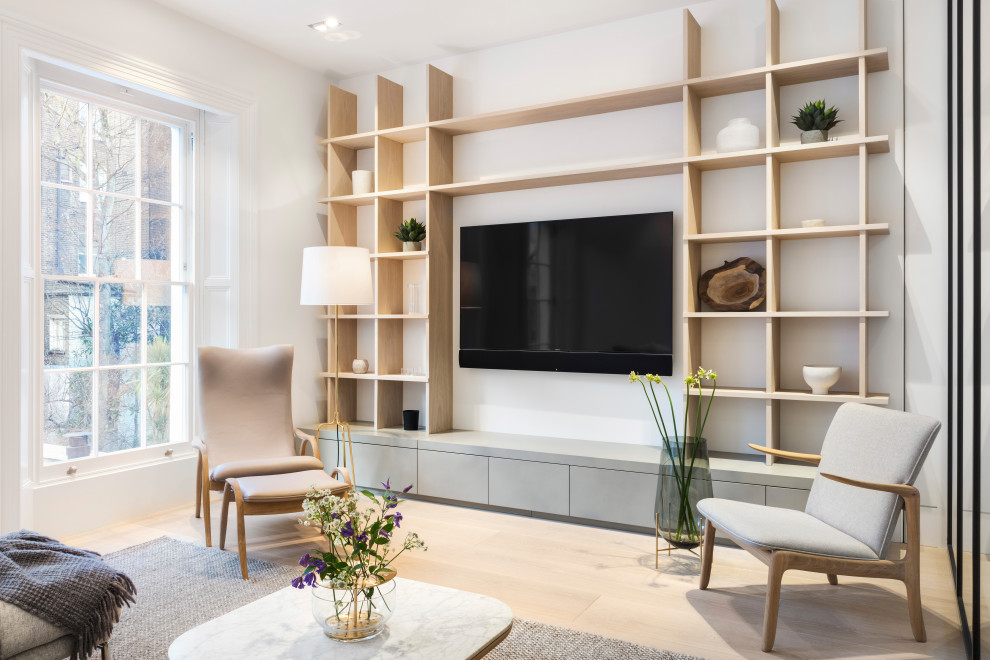 Пример оригинального дизайна: изолированная гостиная комната среднего размера в скандинавском стиле с белыми стенами, светлым паркетным полом, телевизором на стене и коричневым полом без камина