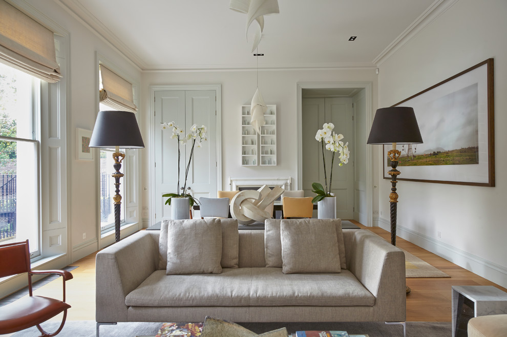 На фото: гостиная комната в классическом стиле с белыми стенами и паркетным полом среднего тона без телевизора