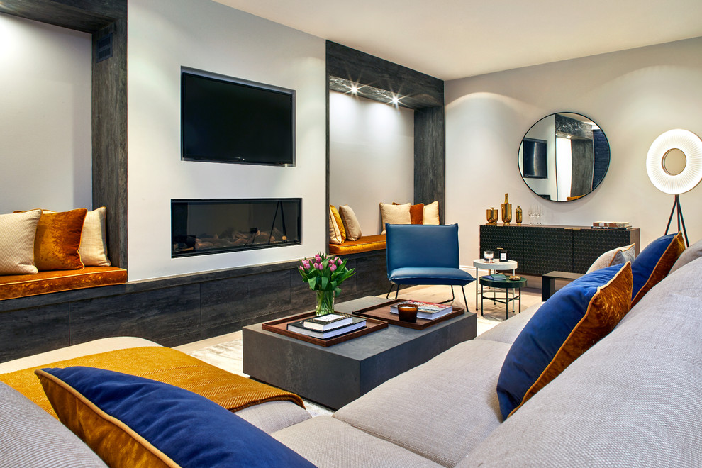 Modern inredning av ett vardagsrum, med grå väggar, ljust trägolv, en bred öppen spis, en spiselkrans i gips och en väggmonterad TV