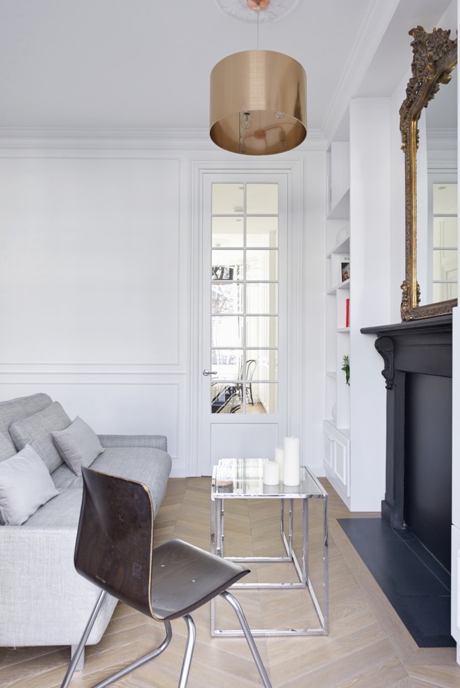 Inspiration for a small victorian open plan living room in London with a reading nook, white walls, light hardwood flooring, no fireplace, a metal fireplace surround, a built-in media unit and brown floors.