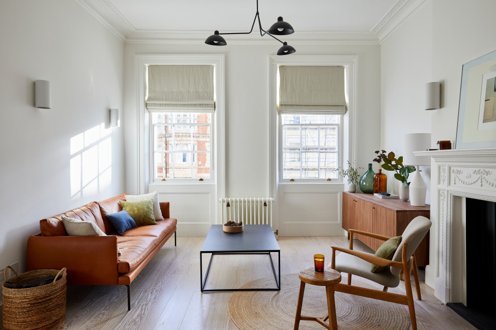 Foto di un piccolo soggiorno minimalista aperto con pareti bianche, parquet chiaro, camino classico e pavimento beige