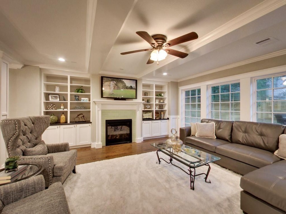 This is an example of a medium sized classic formal open plan living room in Other with beige walls, medium hardwood flooring, a standard fireplace, a tiled fireplace surround, a wall mounted tv and brown floors.