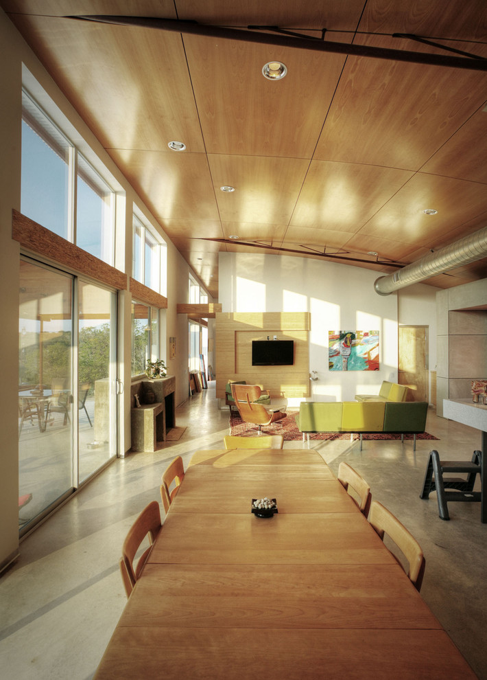 Offenes Industrial Wohnzimmer mit weißer Wandfarbe und Betonboden in Austin