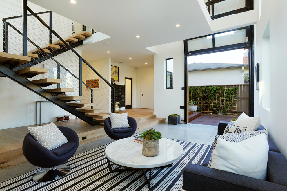 Modernes Wohnzimmer mit weißer Wandfarbe und Betonboden in Los Angeles