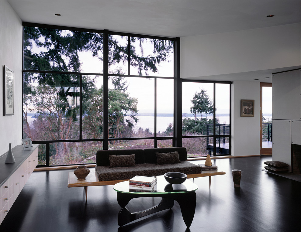 На фото: гостиная комната в стиле модернизм с белыми стенами и коричневым диваном с