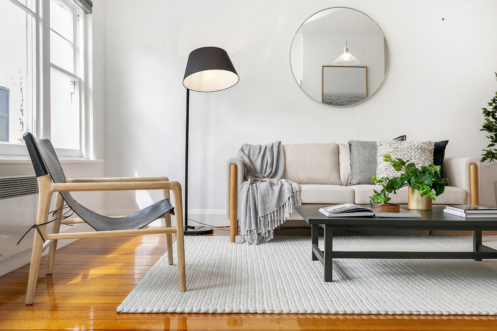 Foto di un soggiorno minimal con pareti bianche, pavimento in legno massello medio e pavimento marrone