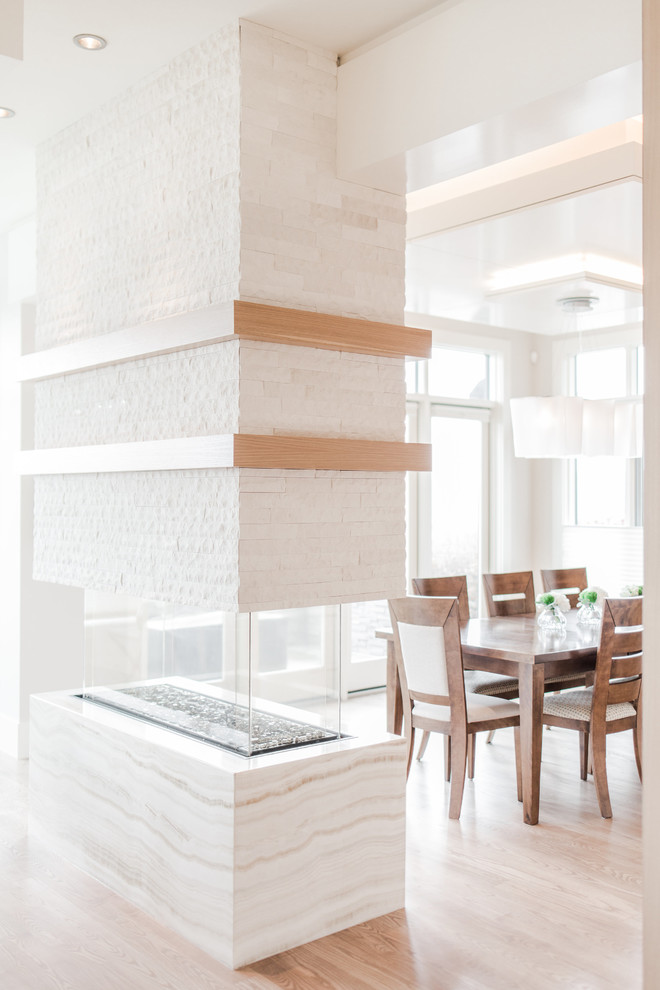 Idées déco pour un très grand salon contemporain ouvert avec un mur blanc, parquet clair et un manteau de cheminée en pierre.