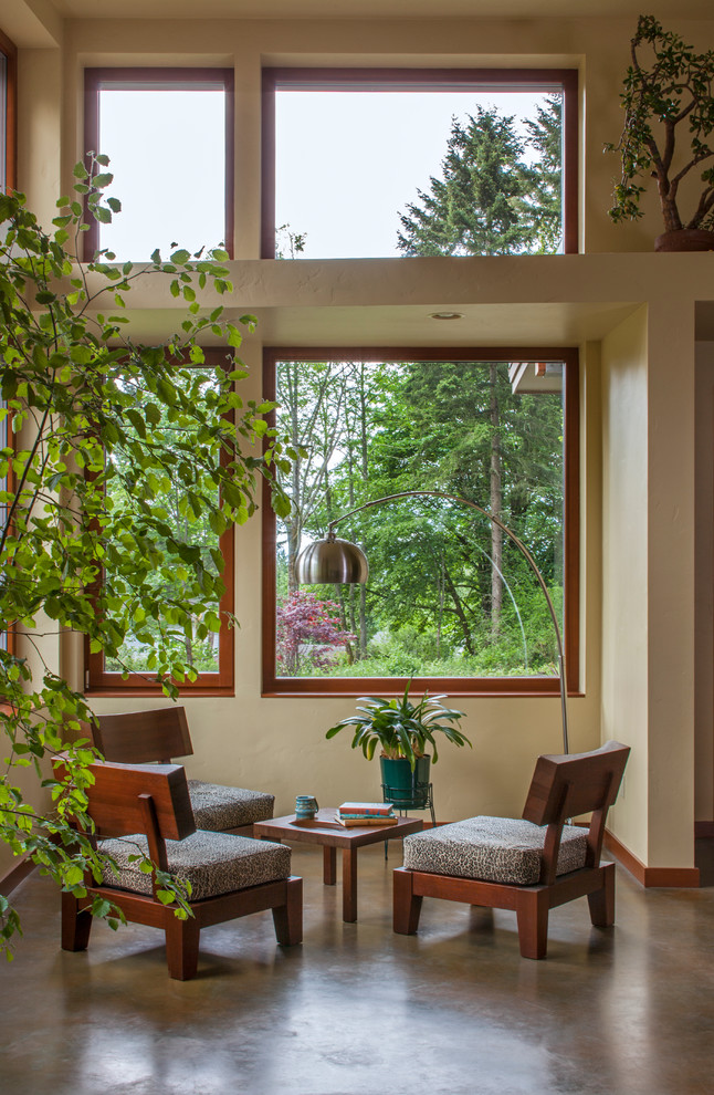 Immagine di un grande soggiorno contemporaneo aperto con pareti beige, pavimento in cemento, nessun camino e pavimento grigio
