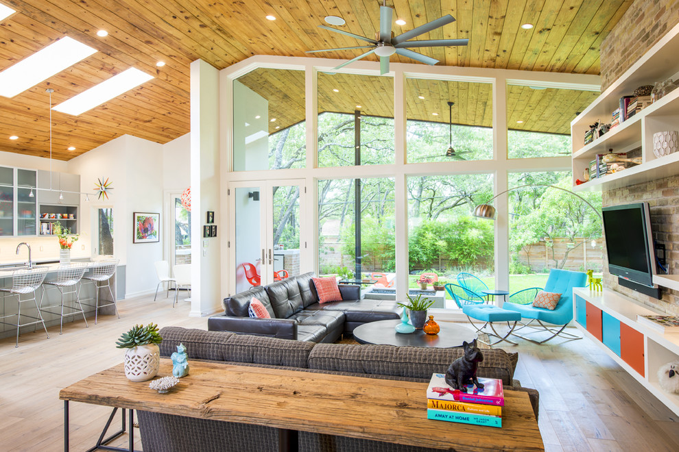 Living room - 1950s open concept light wood floor living room idea in Austin with a wall-mounted tv