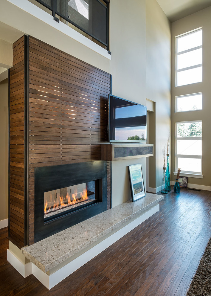 Cette photo montre un grand salon tendance ouvert avec une cheminée double-face, un téléviseur fixé au mur, un mur beige, un sol en bois brun et un manteau de cheminée en bois.
