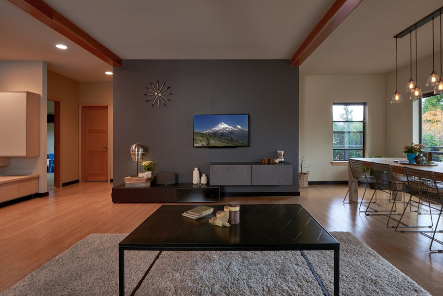 На фото: открытая гостиная комната среднего размера в стиле модернизм с черными стенами, полом из бамбука и телевизором на стене