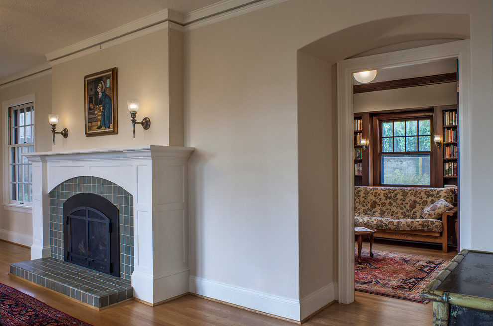Cette photo montre un grand salon craftsman ouvert avec une salle de réception, un mur beige, parquet clair, une cheminée standard et un manteau de cheminée en carrelage.