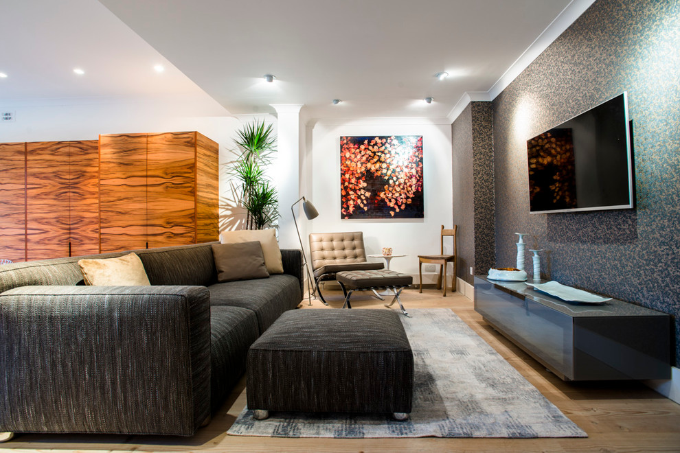 Идея дизайна: гостиная комната среднего размера в современном стиле с синими стенами, светлым паркетным полом и телевизором на стене