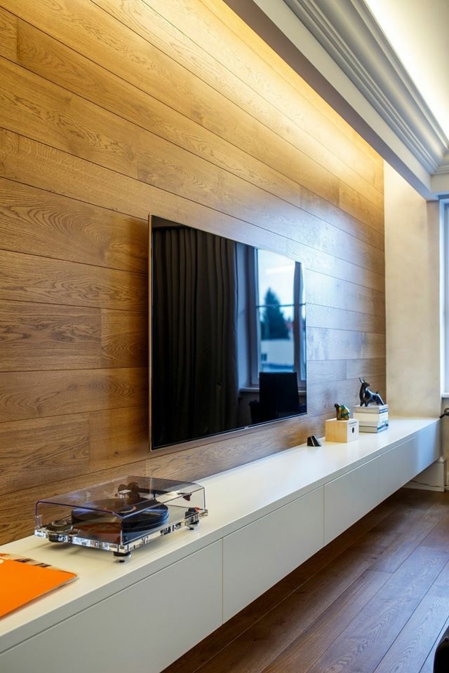 Foto di un grande soggiorno minimalista aperto con pareti marroni, parquet scuro e TV a parete