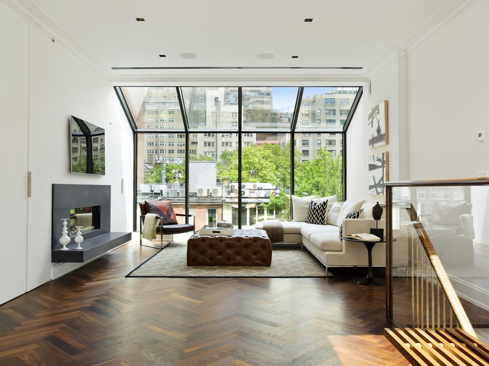 Offenes Modernes Wohnzimmer mit weißer Wandfarbe, dunklem Holzboden, Gaskamin und TV-Wand in New York