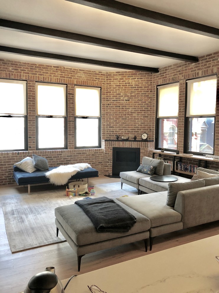 Mittelgroßes Industrial Wohnzimmer im Loft-Stil mit Eckkamin, Kaminumrandung aus Backstein und braunem Boden in New York