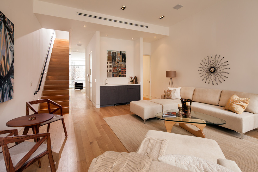 Aménagement d'un salon contemporain ouvert avec un mur beige, un sol en bois brun et un bar de salon.