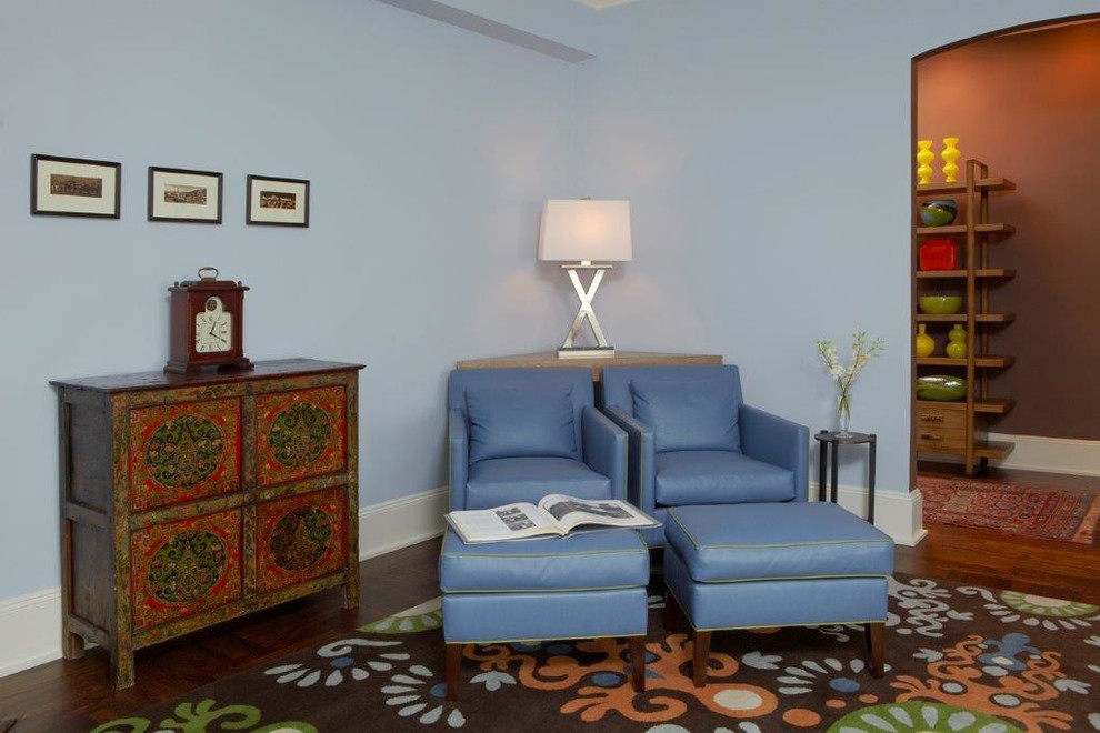 Immagine di un soggiorno boho chic di medie dimensioni e chiuso con pareti blu, pavimento in legno massello medio, camino ad angolo, cornice del camino in legno e TV a parete