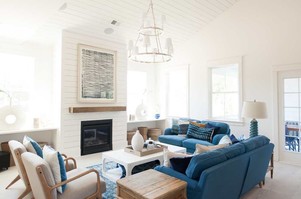 Maritimes Wohnzimmer mit weißer Wandfarbe, braunem Holzboden, Kamin und braunem Boden in Charleston